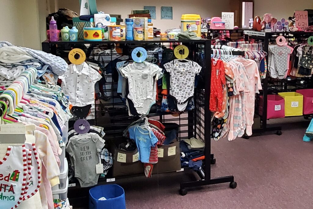 Racks full of onesies and other clothes for babies and toddlers